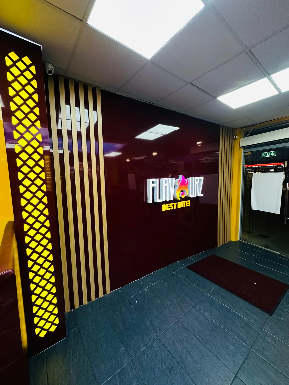 3D shop interior visualisation featuring a branded feature wall, illuminated logo, decorative gold panels and modern entrance design.