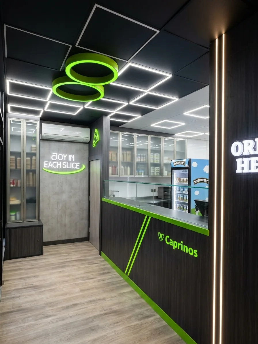 Shop fit-out with a lime green branded counter, illuminated feature wall sign and LED ceiling lighting in a takeaway shop